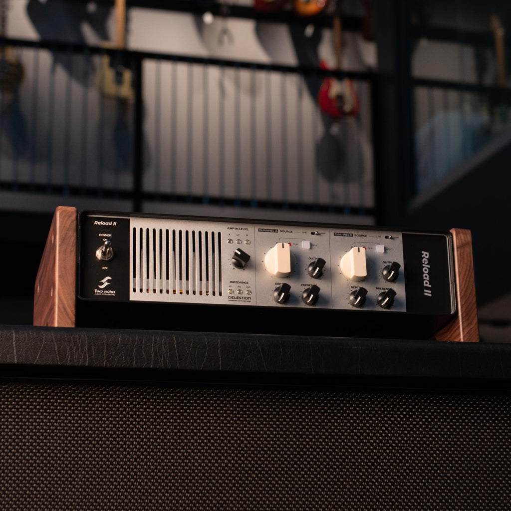 Two Notes Reload II audio device with wooden side panels and multiple rotary knobs and switches on the front panel.