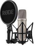 Silver condenser microphone in black shock mount with black pop filter showing RØDE logo.
