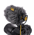 Compact shotgun microphone with furry windscreen mounted on a black camera