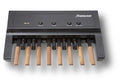 Black MIDI controller with eight wooden keys and four black control knobs labeled above.