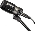 Black professional microphone with a mesh grille mounted on a stand and connected by a cable with a 3-pin connector.