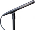 Black shotgun microphone mounted on a stand with a connected audio cable.