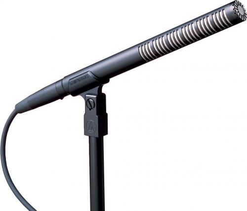 Black shotgun microphone mounted on a stand with a connected audio cable.