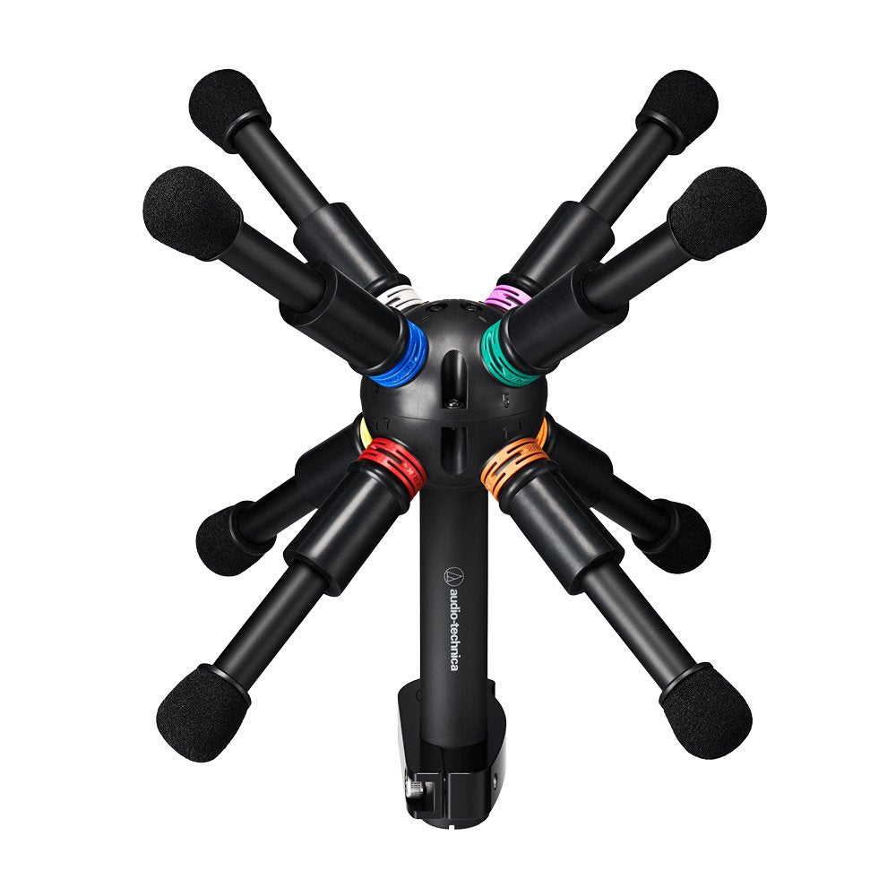 Eight black microphones with colored rings arranged radially around a central hub with the Audio-Technica logo.