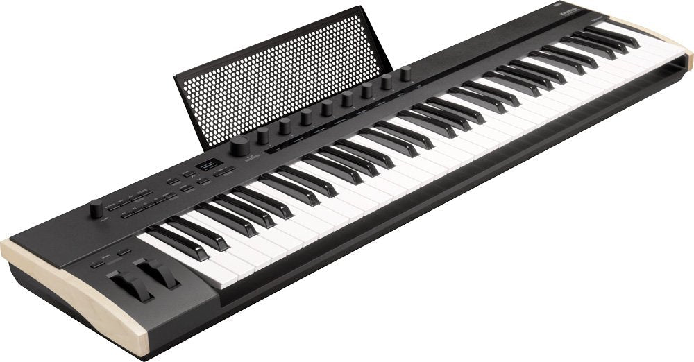Black and beige keyboard MIDI controller with 61 keys, knobs, buttons, pitch bend and modulation wheels, and a music stand.