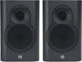 Front view of a pair of dark grey Kii Seven speakers with black speaker grilles and white brand text.