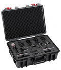Open black hard case containing one handheld microphone, three small clip-on microphones, mounts, and foam padding.