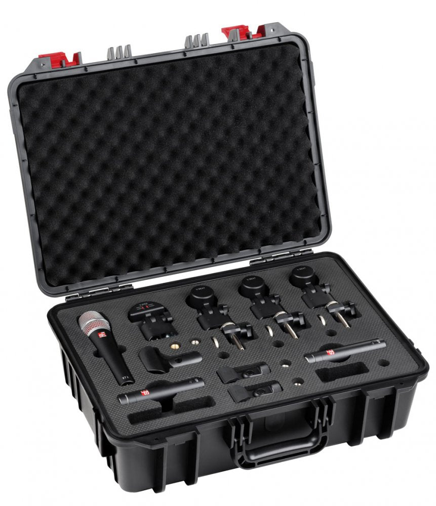 Open black hard case containing one handheld microphone, three small clip-on microphones, mounts, and foam padding.