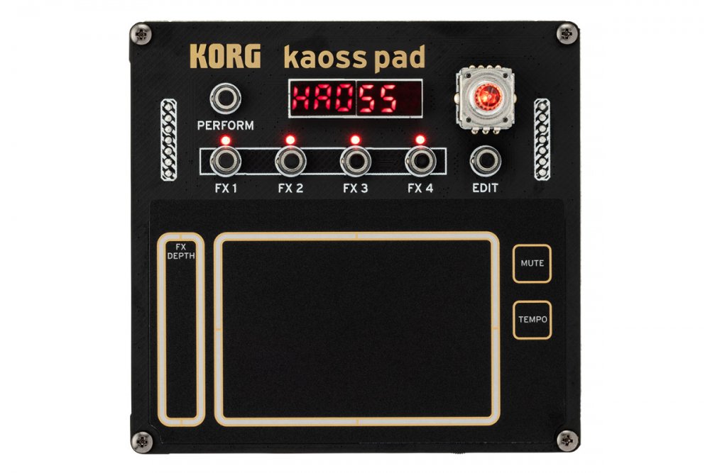 Top view of a black KORG Kaoss Pad with buttons, LED display, touchpad, and pin headers visible.