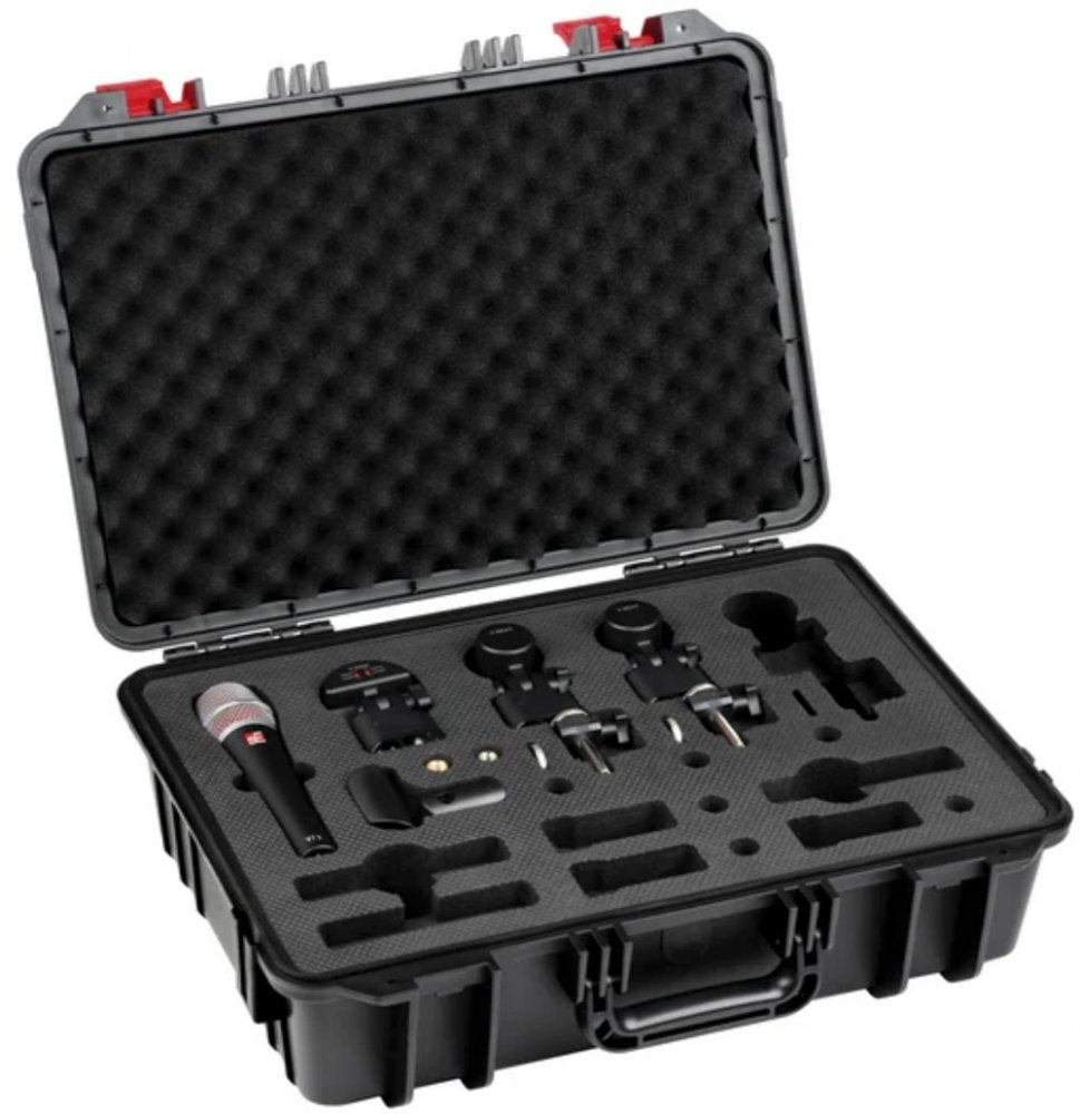 Open black hard case containing a handheld microphone, two wireless microphone units, and mounting clips in protective foam.
