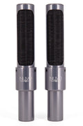 Two tall cylindrical microphones with gray metal bodies and black mesh fronts, labeled NUVO, standing side by side.