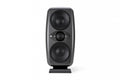 Black studio monitor speaker with two large drivers and one smaller driver in the center on a stand.