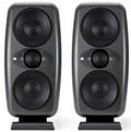 Pair of black speakers each with three visible drivers and stand, front view.