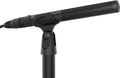 Black shotgun microphone mounted on a stand with an attached XLR cable visible