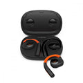 Black and orange wireless earbuds with ear hooks resting in and outside a black charging case.