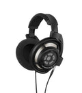 Black over-ear wired headphones with visible metal driver and foam ear pads.