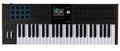 Black MIDI controller keyboard with 49 keys, pads, faders, knobs, and a central display screen.