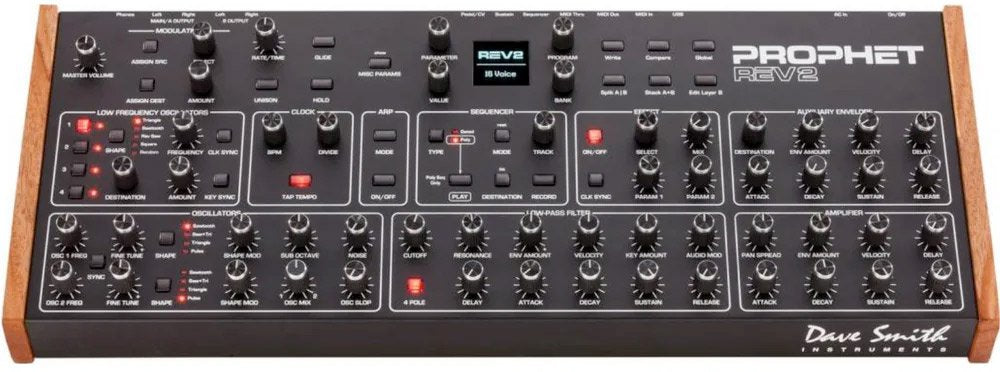 Black analog synthesizer module with multiple knobs, buttons, wood side panels, and digital screen labeled REV2.