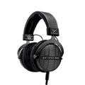 Black over-ear headphones with visible cable connector and cushioned ear pads, labeled DT 1990 PRO