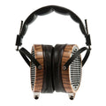 Over-ear headphones with wooden earcups and black padded headband shown from the front.