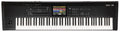Black keyboard synthesizer with multiple keys, knobs, faders, buttons, a joystick, and a central color touchscreen display.