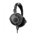Black over-ear open-back headphones with metal mesh ear cups and dual detachable cables, shown from angled front view.