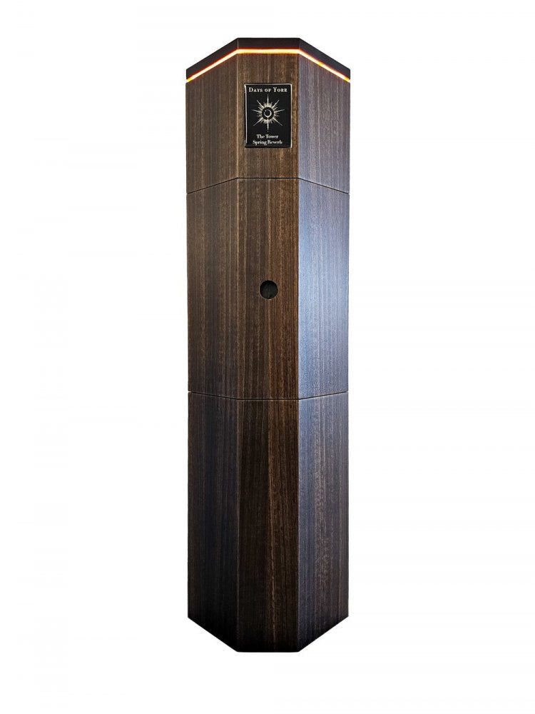 Tall hexagonal wooden tower-shaped device with an illuminated top and a label reading Days of Yore The Tower Spring Reverb.