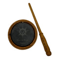 Round wooden sound generator with a black drum head and a wooden striker stick beside it.