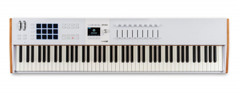 White 88-key MIDI controller keyboard with pads, sliders, knobs, buttons, and a small screen