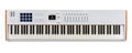 White 88-key MIDI controller keyboard with pads, sliders, knobs, buttons, and a small screen