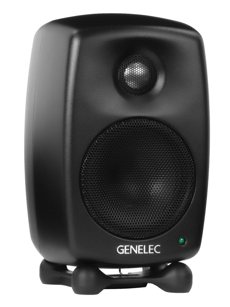 Black Genelec studio monitor speaker with metal mesh covers and isolating stand on white background.