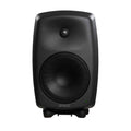 Black studio monitor speaker with metal mesh covering two drivers and a green power indicator light.