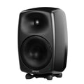 Black studio monitor speaker with brand name Genelec on the front and a protective mesh grille on the driver cones.