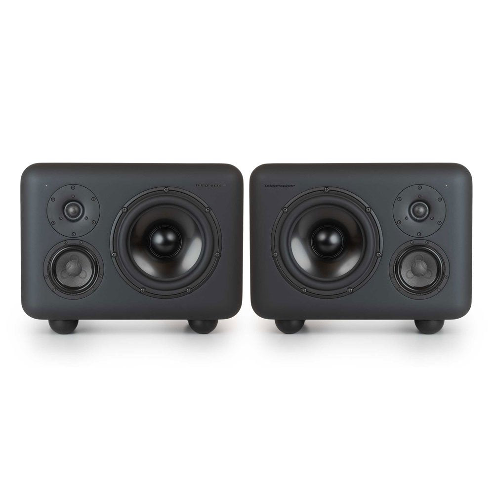 Two black studio monitors each with three speaker drivers and rounded corners on a white background.