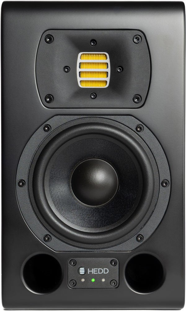 Front view of a black studio monitor speaker with a yellow component and dual circular ports at the bottom.