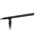 Black shotgun microphone mounted on a stand with a cable attached at the rear
