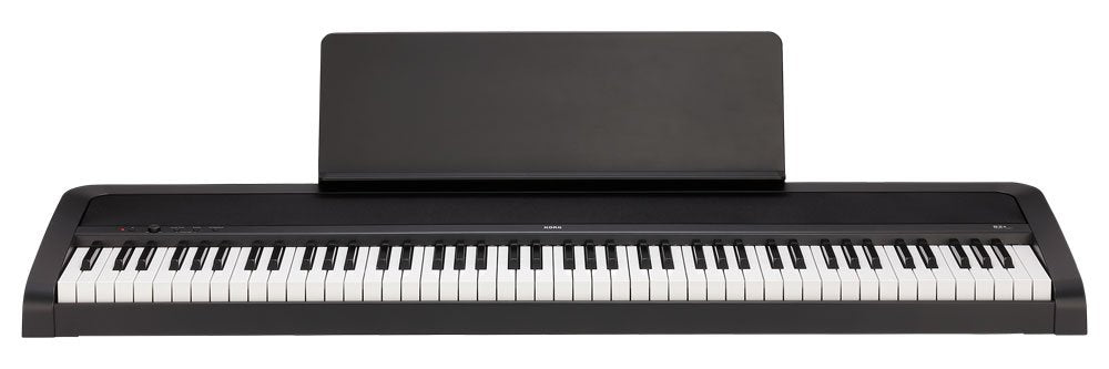 Black electronic keyboard piano with white and black keys and a music stand attached.