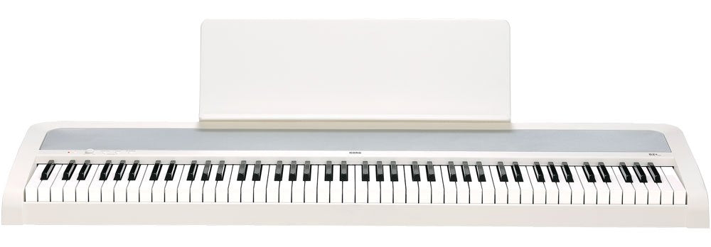 White digital piano keyboard with music stand and KORG branding on the front panel.