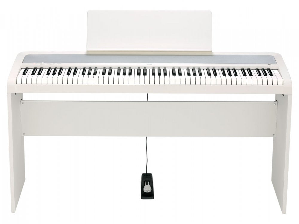 White digital piano keyboard with stand, music rest, and sustain pedal connected by a cable.