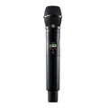 Black handheld wireless microphone with a mesh head and digital display showing channel information.