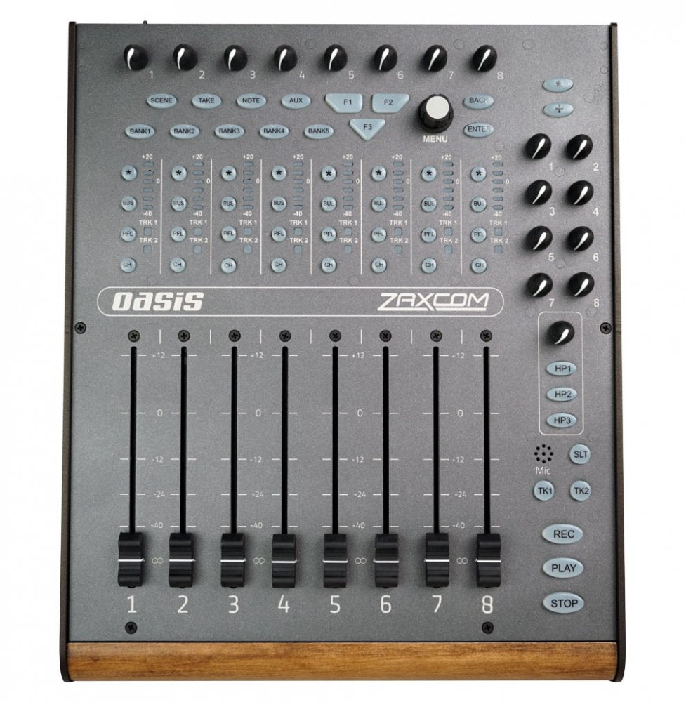 Top view of a Zaxcom Oasis audio mixer with knobs, faders, and multiple buttons on a gray panel with wood trim.