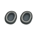 Two black oval replacement ear pads for headphones with fabric inner mesh and leather-like outer covering.