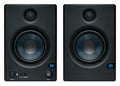 Front view of two black studio monitor speakers with blue cones and control knobs on left unit.