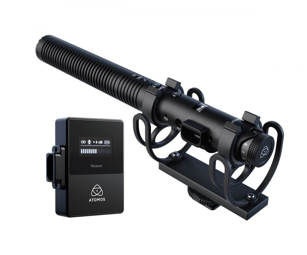 Black shotgun microphone mounted in shock mount with a small black wireless receiver unit labeled ATOMOS.