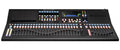 Black audio mixer console with 32 motorized faders, control buttons, rotary knobs, and a touchscreen display.