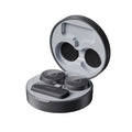 Black wireless earbuds and a microphone in a round charging case with lid open.