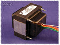 Black power transformer with multiple colored wire leads and mounting screws on a purple background.