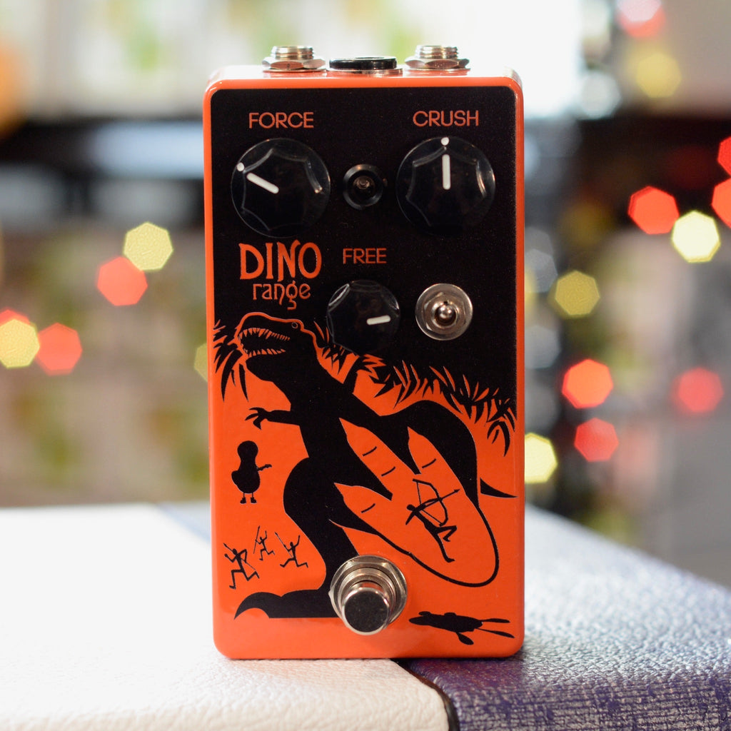 Orange pedal with dinosaur graphic and three knobs labeled Force, Crush, and Free plus a toggle switch and footswitch.