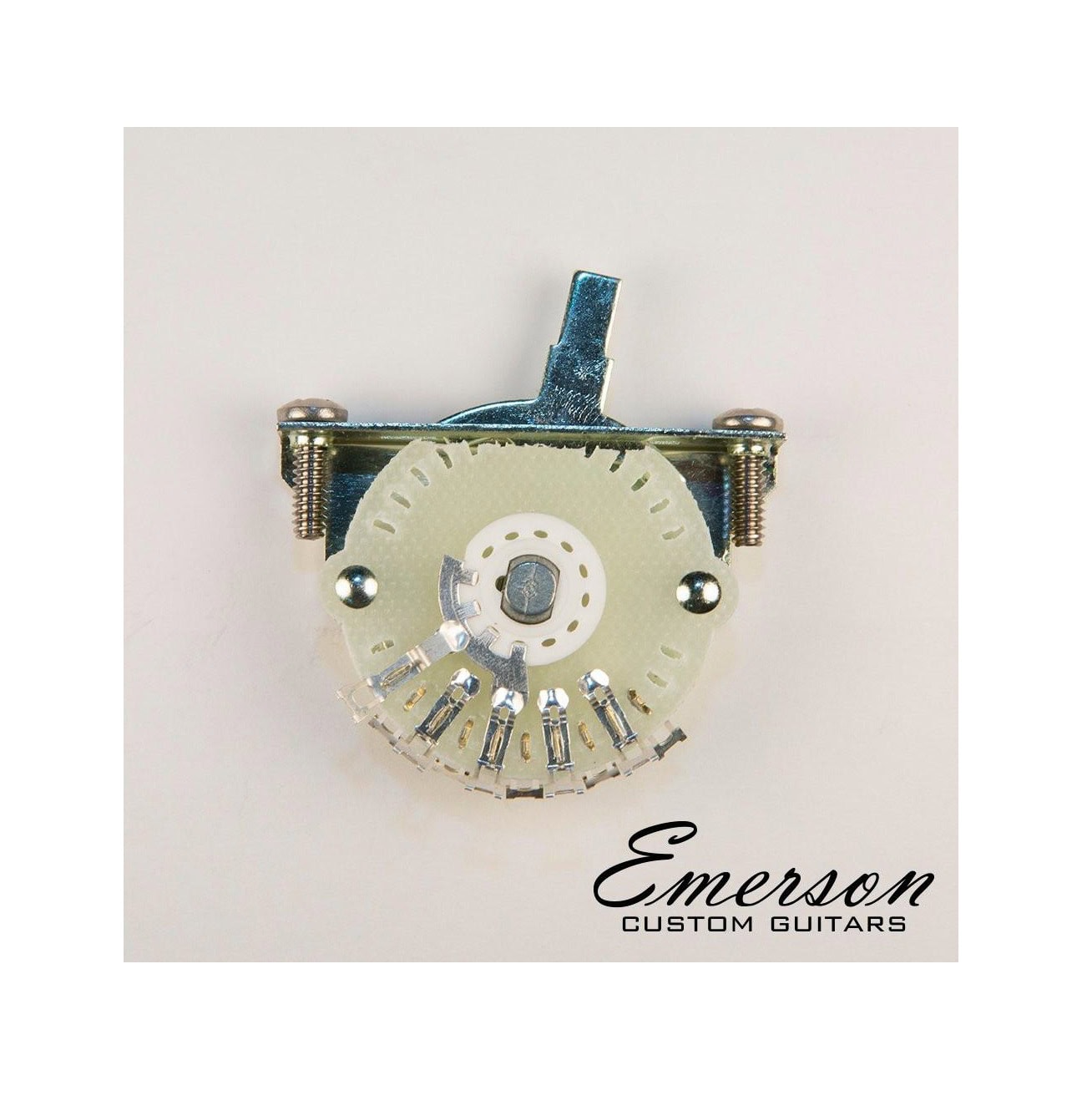 Metal lever switch with terminal lugs mounted on a light background with Emerson Custom Guitars branding.