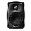 Front view of a black Genelec studio monitor speaker with metal mesh over drivers and a green indicator light.